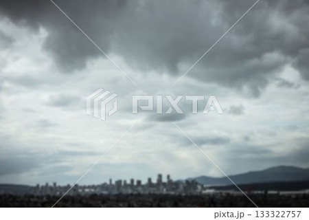 Showing flat design urban skyline stretching wide with foothill mountains under heavy clouds 133322757