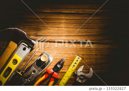 Flat design showing hand tools aligning left on wooden workbench with warm lighting, showing grain 133322827
