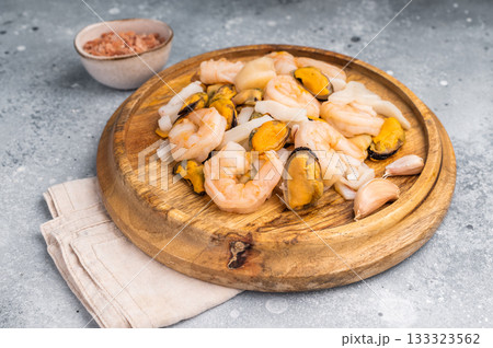 Frozen Raw Seafood Cocktail with Mussels, Clams, Prawns, Shrimps and squid. grey background. top view Frozen Raw Seafood Cocktail with Mussels, Clams, Prawns, Shrimps and squid. grey background. top view 133323562