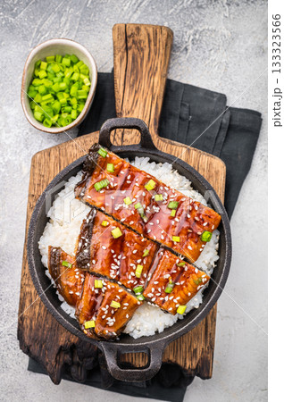 Japanese Cuisine Unadon, grilled unagi eel with rice in a skillet. white background. top view 133323566