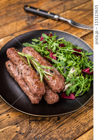 Balkan BBQ roast Cevapcici Sausage, roasted Cevapi from mince beef and pork meat. wooden background. top view 133323635