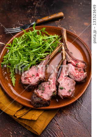 Roasted lamb chop cutlets, mutton meat steaks with salad. brown background. top view Roasted lamb chop cutlets, mutton meat steaks with salad. brown background. top view 133323649