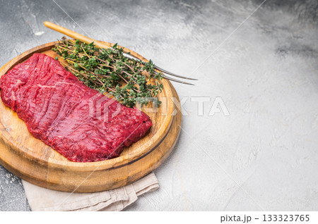 Flank steak, raw beef meat with herbs for frying. grey background. top view 133323765