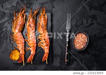 Shrimp kebab, Skewers with Grilled red Prawns Langostino Austral. black background. top view 133323954