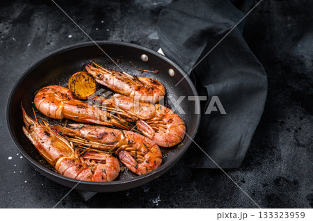 Pan fried red Argentine shrimps, Prawns Langostino Austral with herbs. black background. top view Pan fried red Argentine shrimps, Prawns Langostino Austral with herbs. black background. top view 133323959