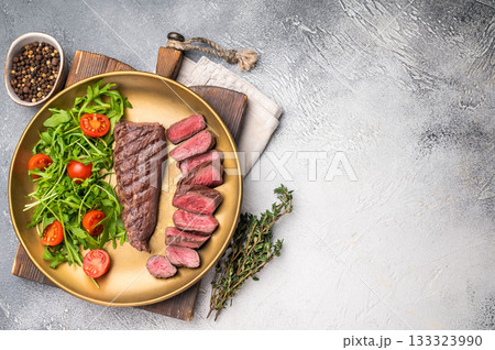Grill Goat steak, roasted tenderloin fillet meat with salad. grey background. top view 133323990