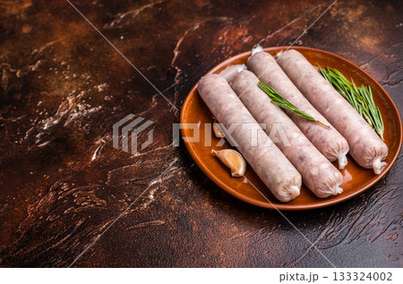 Raw Sausages with forcemeat mincemeat with herbs in plate. brown background. top view Raw Sausages with forcemeat mincemeat with herbs in plate. brown background. top view 133324002