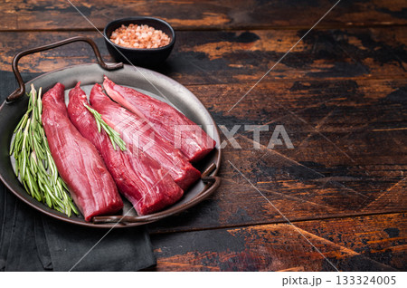Ready for cooking raw lamb tenderloin fillet meat, fresh loin mutton. wooden background. top view 133324005