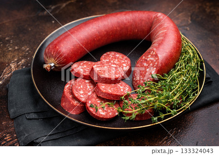 Sliced and whole Turkish sucuk (sujuk) in a cast iron pan with thyme. Spicy dry-cured sausage, top view. Sliced and whole Turkish sucuk (sujuk) in a cast iron pan with thyme. Spicy dry-cured sausage, top view. 133324043