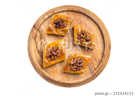 Arabic Traditional Honey Walnut Baklava on wooden board isolated on white background. top view Arabic Traditional Honey Walnut Baklava on wooden board isolated on white background. top view 133324115