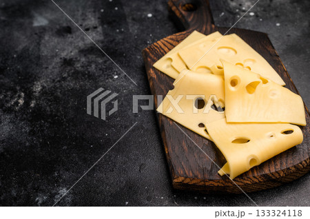 Swiss emmental cheese slices on wooden cutting board. black background. top view 133324118
