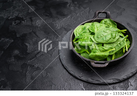 Crisp and lush fresh spinach ready for your favorite recipes, a versatile superfood for every meal. black background. top view 133324137