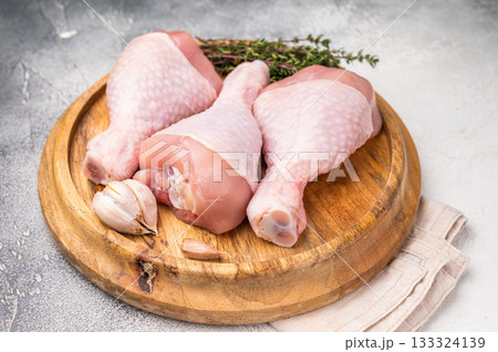 Raw poultry drumsticks, chicken legs ready for cooking with herbs and spices. white background. top view Raw poultry drumsticks, chicken legs ready for cooking with herbs and spices. white background. top view 133324139