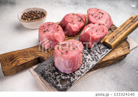 Juicy uncooked pork medallion, raw loin meat a versatile choice for stir fries or savory roasts in any cuisine. white background. top view Juicy uncooked pork medallion, raw loin meat a versatile choice for stir fries or savory roasts in any cuisine. white background. top view 133324140