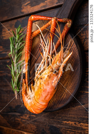 Juicy grilled giant river prawn shrimp served with rosemary, a mouthwatering dish for your next barbecue. wooden background. top view 133324176
