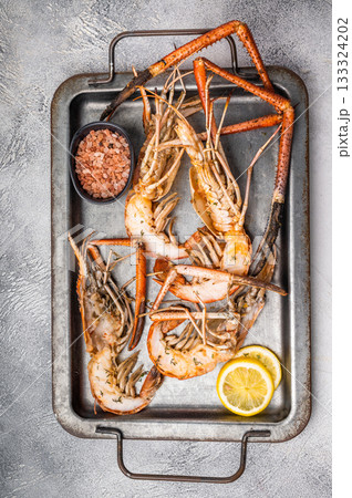 Deliciously grilled giant river prawns on steel tray, ideal for summer gatherings and outdoor feasts. white background. top view Deliciously grilled giant river prawns on steel tray, ideal for summer gatherings and outdoor feasts. white background. top view 133324202