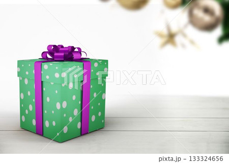 Green polka-dot gift box is sitting on tabletop in flat design, gold baubles and star ornament 133324656