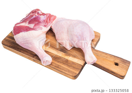 Raw duck leg presented against a clean white surface, perfect for culinary stock imagery. Raw duck leg presented against a clean white surface, perfect for culinary stock imagery. 133325058
