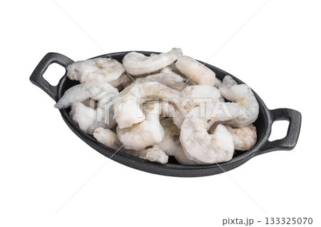 Top view of icy uncooked shellfish (shrimp) in a small black skillet. Protein-rich, healthy ingredient for quick dinner recipes. 133325070