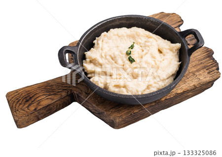 Creamy horseradish sauce in a rustic black cast iron bowl, garnished with a fresh sprig of thyme. Isolated on white background. 133325086
