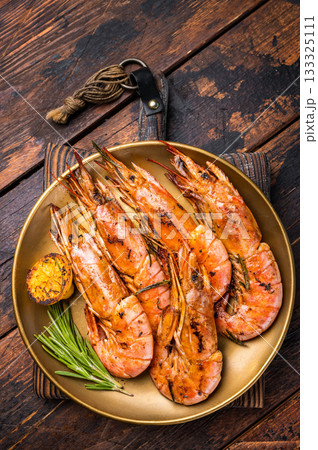 Grilled red Argentine shrimps, Prawns Langostino Austral on a plate with herbs. wooden background. top view 133325111