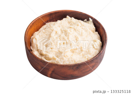 Creamy homemade horseradish sauce served in a rustic wooden bowl on a clean white background. Classic studio top view. 133325118