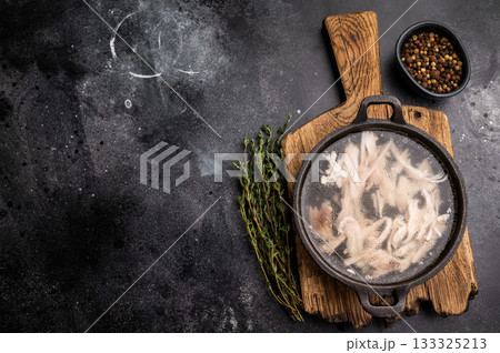 Chicken broth with meat, chicken soup in a skillet. black background. top view 133325213