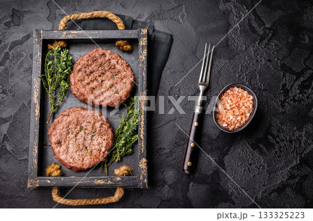Grilled hamburger mince meat patties with herbs. black background. top view 133325223