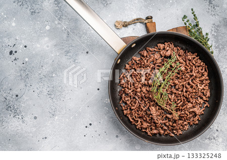 Frying Pan with fried mince beef meat, fresh cooked forcemeat. grey background. top view 133325248