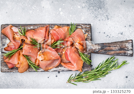 Italian Prosciutto ham, Parma ham on wooden board with rosemary. grey background. top view 133325270