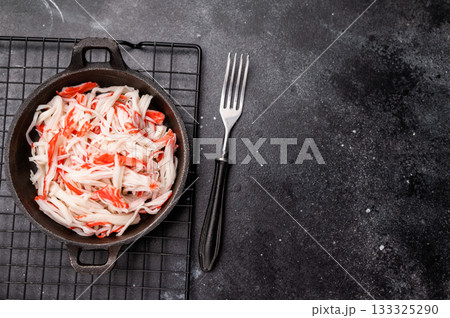 japanese Crab meat, crabmeat imitation in a skillet. black background. top view japanese Crab meat, crabmeat imitation in a skillet. black background. top view 133325290