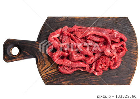 Uncooked Raw beef sliced meat, strips for cooking beef stroganoff on wooden board isolated on white background 133325360