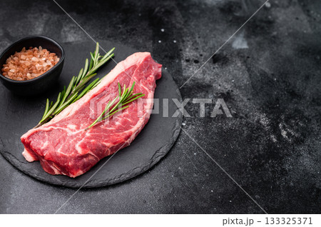 Fresh raw striploin New York steak, perfect for grilling or pan searing, ideal for a delicious homemade meal. black background. top view 133325371