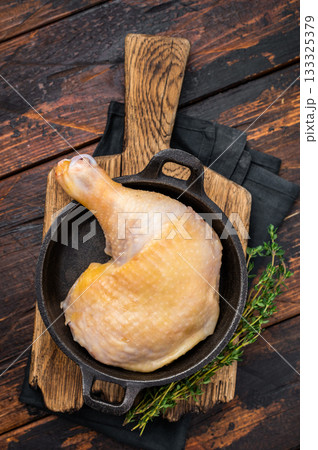 Raw farm chicken leg in a skillet ready for cooking, poultry fresh meat on wooden background, top view. Raw farm chicken leg in a skillet ready for cooking, poultry fresh meat on wooden background, top view. 133325379