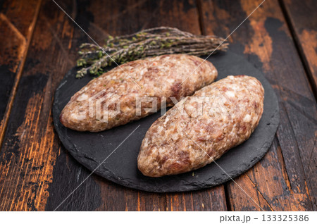 A platter of raw lula kebabs marinated in aromatic herbs, perfect for barbecuing or grilling at your next gathering. wooden background. top view 133325386