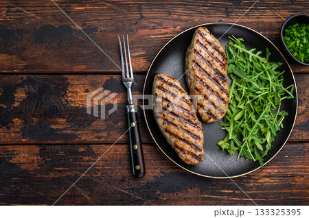 A platter of flavorful bbq roast kofta kebabs, beautifully garnished with vegetables and ready to delight your taste buds. wooden background. top view A platter of flavorful bbq roast kofta kebabs, beautifully garnished with vegetables and ready to delight your taste buds. wooden background. top view 133325395