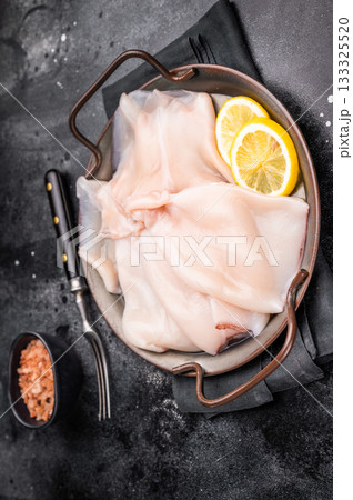 Fresh raw squid ready for preparation, perfect for sushi, stir-fries, or gourmet seafood dishes. black background. top view 133325520