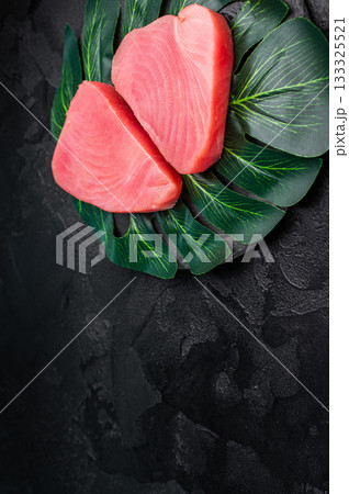 Beautifully cut raw tuna steak, rich in flavor and omega 3s, ready to elevate your culinary creations. black background. top view 133325521
