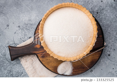 Versatile white sugar in a rustic bowl, ready to enhance desserts and beverages with its delightful sweetness. grey background. top view Versatile white sugar in a rustic bowl, ready to enhance desserts and beverages with its delightful sweetness. grey background. top view 133325525