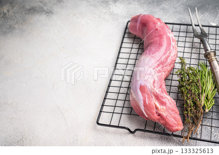 Uncooked pork loin fillet, raw tenderloin ready to be seasoned and transformed into a delicious centerpiece for dinner. white background. top view Uncooked pork loin fillet, raw tenderloin ready to be seasoned and transformed into a delicious centerpiece for dinner. white background. top view 133325613