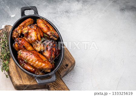 Grilled chicken wings smothered in sweet and sour sauce, poultry meat. white background. top view Grilled chicken wings smothered in sweet and sour sauce, poultry meat. white background. top view 133325619