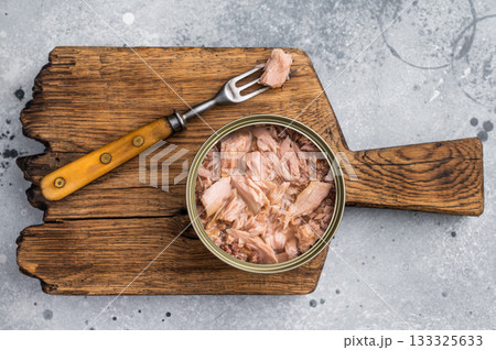 Delicious canned tuna in olive oil, ideal for salads, sandwiches, or as a savory snack on the go. grey background. top view 133325633