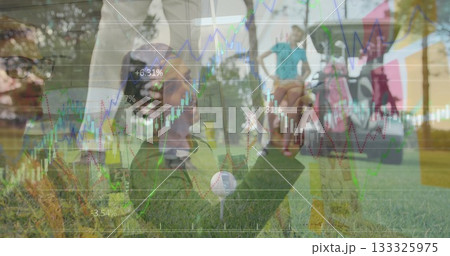 Kneeling man placing golf ball on tee on sunlit fairway, with golf cart and financial charts 133325975