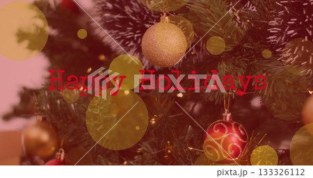 Highlighting Christmas tree at home with glittery decor, lights, bokeh and Happy Holidays overlay Highlighting Christmas tree at home with glittery decor, lights, bokeh and Happy Holidays overlay 133326112