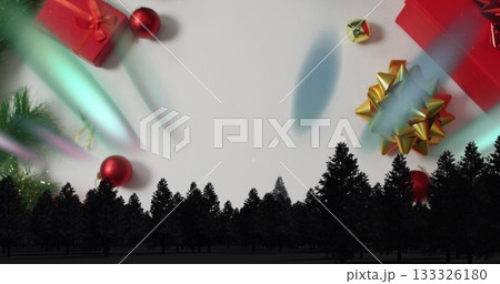 Displaying pine tree silhouette forming horizon on white backdrop, with gift boxes and baubles 133326180