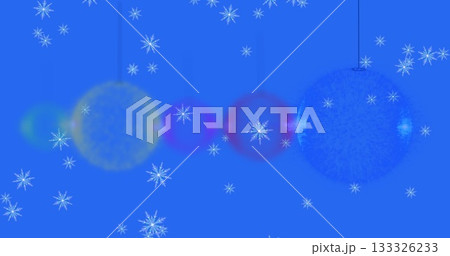 Displaying glowing yellow magenta blue ornaments hanging on blue backdrop, with white snowflakes Displaying glowing yellow magenta blue ornaments hanging on blue backdrop, with white snowflakes 133326233