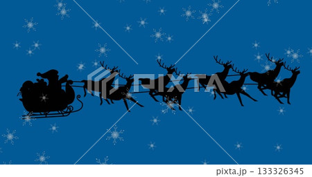 Flying Santa through deep blue sky, with eight reindeer pulling sleigh with gift sack, falling snow 133326345