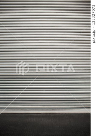 Flat vector metal roll-up shutter door spanning frame, showing ridges, resting on textured floor Flat vector metal roll-up shutter door spanning frame, showing ridges, resting on textured floor 133327073