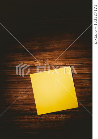Square shaped yellow paper on wooden floor 133327171
