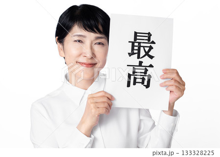 最高と書かれた紙を両手で持ち微笑む白いシャツを着たシニア女性 最高と書かれた紙を両手で持ち微笑む白いシャツを着たシニア女性 133328225